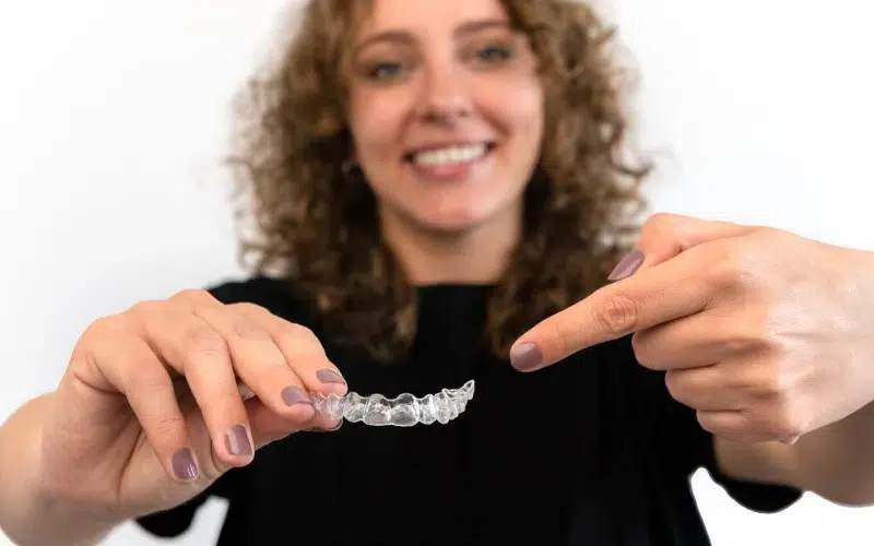 adult-woman-pointing-hand-dental aligner retainer beautiful teeth treatment