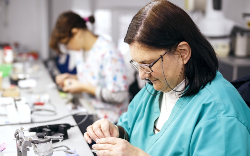 female-dental-technician working on a dental prosthesis in the d