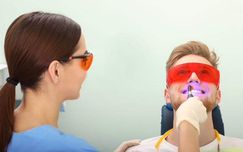 professional dentist working with patient in-modern clinic teeth whitening