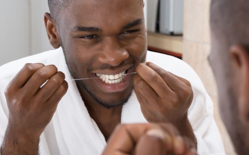african man cleaning his teeth